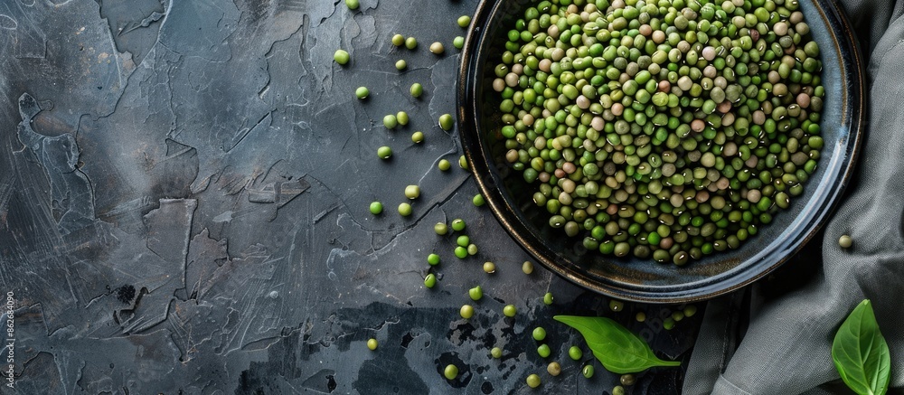Aufkleber Mung beans in a plate with legumes in a bowl in the background, displayed from a top view with room for text or graphics alongside the image. Copy space image. Place for adding text and design