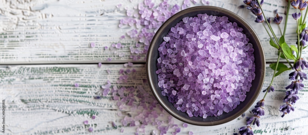 Poster a bird's-eye view of lavender sea salt crystals in a bowl on a white wooden surface, offering space 