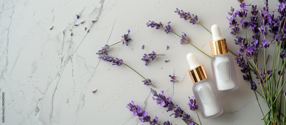 Poster Grey background hosts two unbranded cosmetic serum bottles beside a lavender bunch. The view is top-down with ample room for text or graphics - a copy space image.