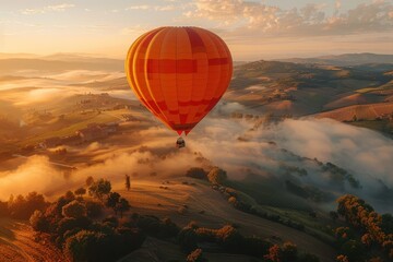 Obraz premium A majestic hot air balloon floating over a picturesque landscape of rolling hills and fields at dawn. 