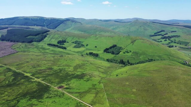 Aerial view of lush green hills and fields in Penchrise Penn, Hawick, Scotland, United Kingdom.