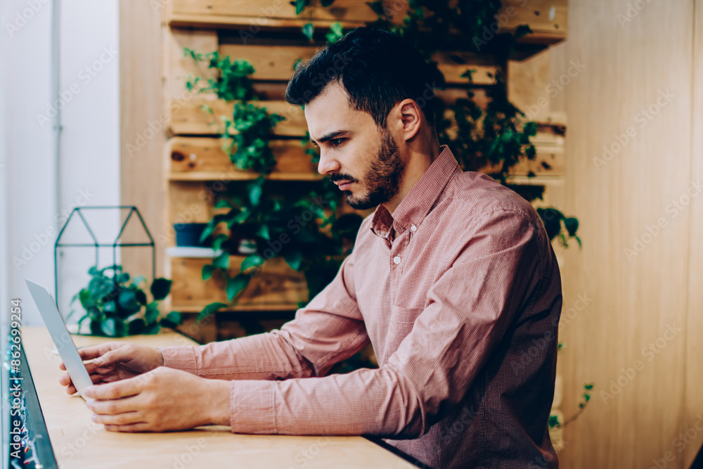 Poster disappointed male freelancer reading bad news about project failure via laptop computer, sad hipster