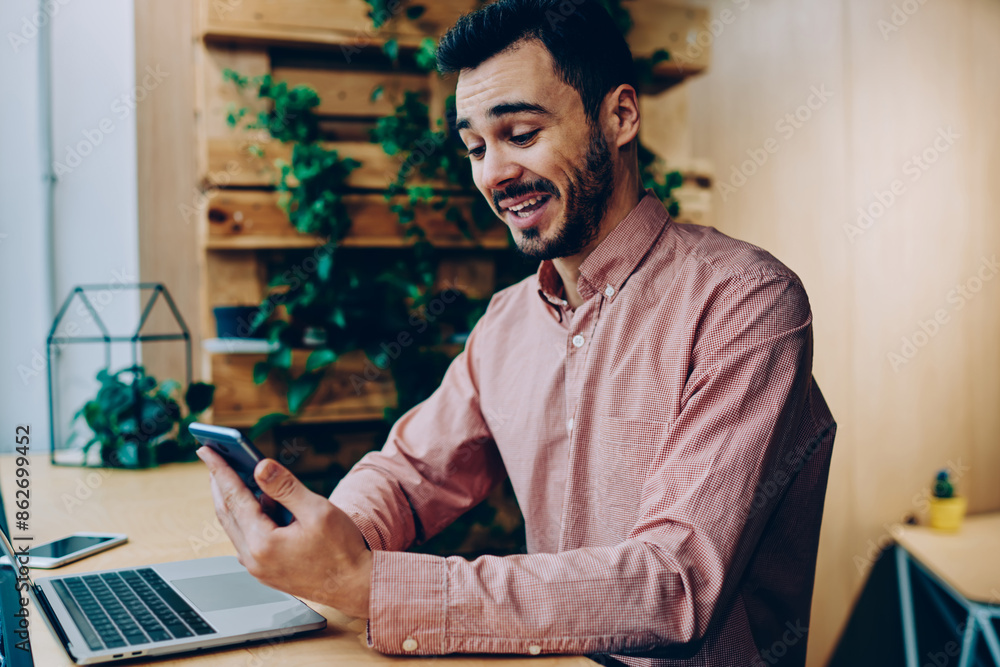 Poster wondered bearded guy amazed with text message reading mail on smartphone, emotional hipster guy laug