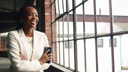Fototapeta premium Confident Businesswoman Smiling in Modern Industrial Office