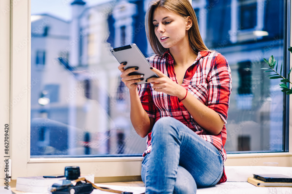 Poster young female student puzzled on information from online book while preparing coursework late in cowo