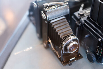 Front view of an old antique bellows film camera. An old vintage camera on a table with blurred background