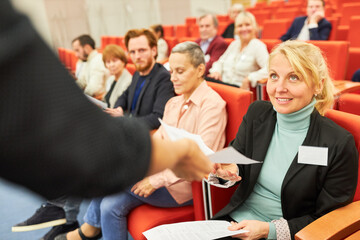 Businesswoman receiving form during conference at corporate event
