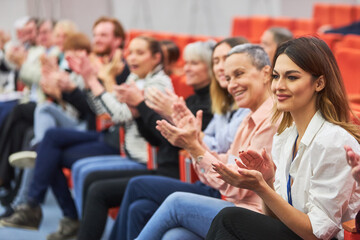 Audience clapping during business event in convention center