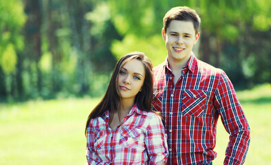 Obraz premium Portrait happy smiling caucasian young couple together outdoors standing in summer park