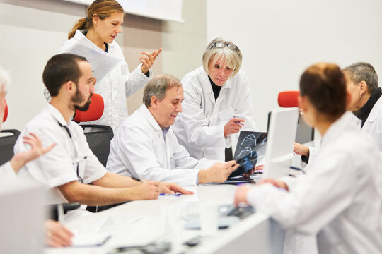 Panel at medical conference discussing over x-ray in auditorium