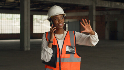 Female Architect Wearing Safety Gear Discussing Construction Project on Phone Call