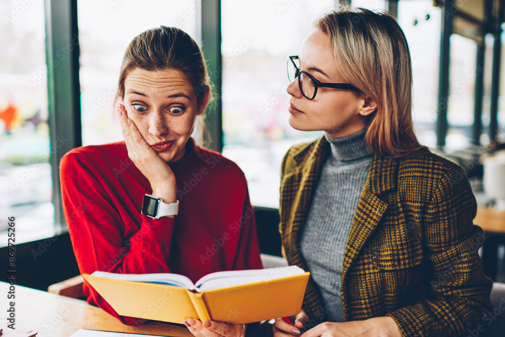 Poster shocked skilled student reading textbook with confused information during private lesson with qualif
