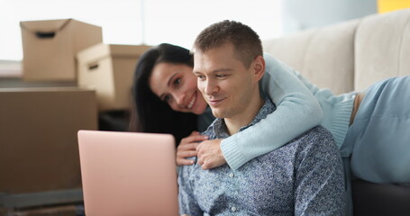 Woman hugs man against background of boxes in an apartment. Rent and purchase of housing concept