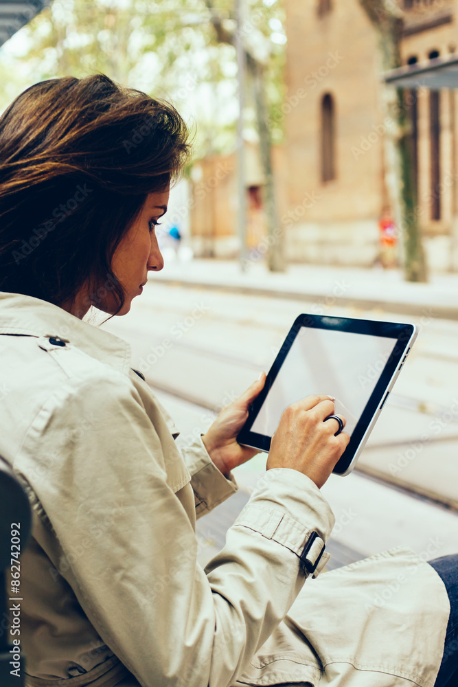 Poster young woman typing text on modern touch pad device with mock up area for your website content sittin