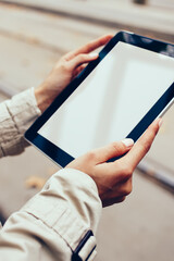 Cropped view of hipster girl holding digital tablet with blank screen area for your internet website.Installing application on modern touch pad device with copy space in woman's hands