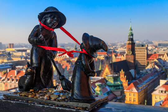 Sculpture Witches Tekla and Martynka dwarfs with coins against amazing Wroclaw city view at Penitents Bridge of St. Mary Magdalene's Church. One of the most famous Wroclaw gnomes