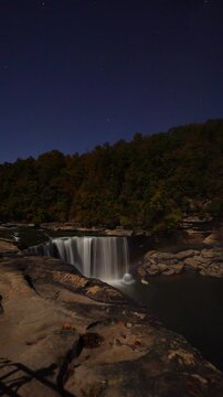 Vertical Video - Moonbow Rainbow Full Moon Waterfall Cumberland Falls State Park Timelapse. Nighttime starry sky Tourist Destination Natural Phenomenon