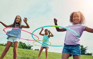 Portrait, hula hoop and kids in park, girls and happiness with fun, bonding together and playful. Childhood, outdoor or friends with recreation, game or cheerful with weekend break, summer or leisure