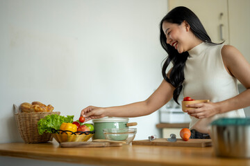 A woman is smiling while preparing food in a kitchen