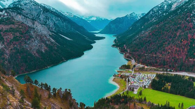 Aerial drone view Plansee lake among snow-capped mountains in Tyrolean Alps, Austria late autumn in cloudy weather. High quality 4k footage