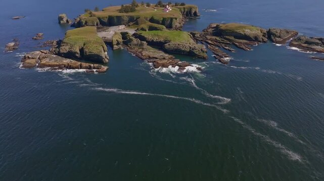 Aerial view of rocky cliffs and waves at Cape Flattery Lighthouse, Pacific Ocean, Washington, United States.