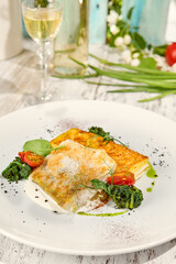 Crispy Battered Pike-Perch with Potato Gratin Served on Wooden Table in Sunlight