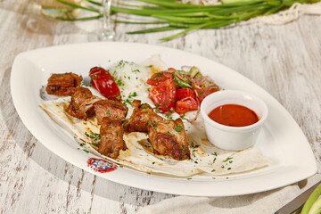 Juicy Pork Skewers with Lavash, Sauce, and Fresh Vegetable Salad in Sunlight