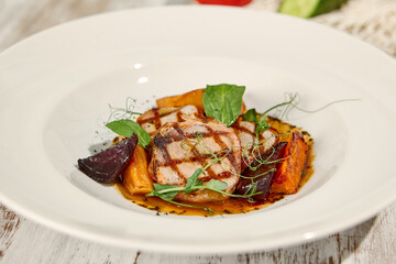 Grilled Pork Medallions with Roasted Vegetables in Sunlit Wooden Setting