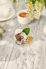 Refreshing Ice Cream Scoop in a Crystal Dessert Dish with Sunlit Wooden Background