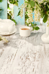 Summer Tea Party with Flowers on Rustic Wooden Table in Sunlight - Perfect for Relaxation Themes