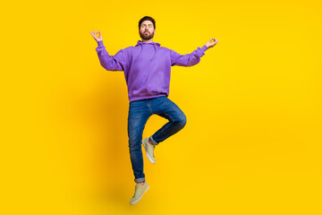 Full size photo of handsome young guy flying meditate wear trendy violet outfit isolated on yellow color background