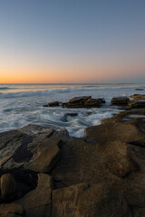 Beautiful morning pastel sky over rocky coastline.