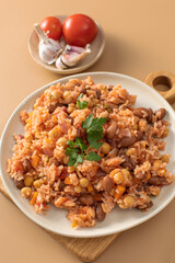Jambalaya with rice chickpeas and kidney beans on beige table