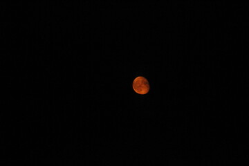 View of the red moon from the window of a moving train