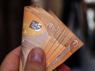 Curved Euro Bills Held by Hand