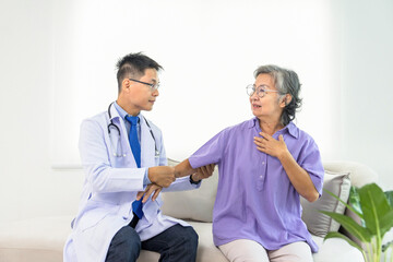 Fototapeta premium asian senior woman being elbow examined by professional doctor due to joint pain in counseling room,concept of elderly life,health care and medical