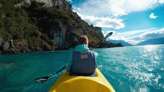 Woman paddles kayak in the clean lake in Chilean Patagonia