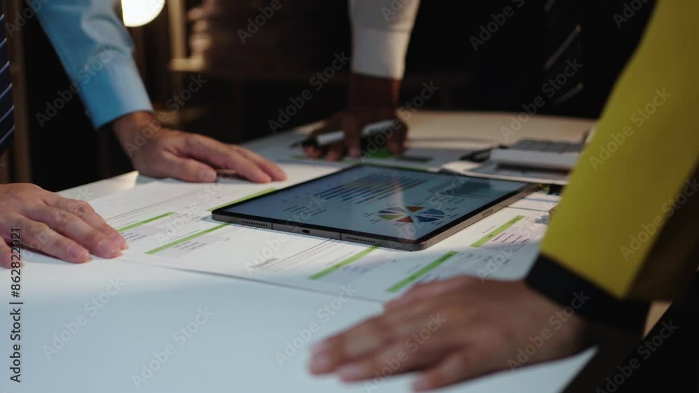 Poster Dynamic meeting with professionals analyzing business data on a tablet in a modern office. Emphasizing teamwork, discussion, and planning