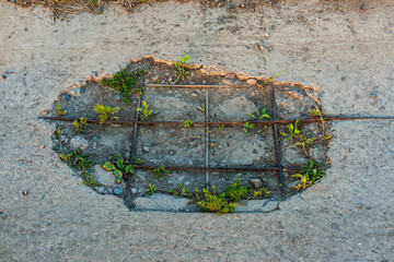 Large hole in a concrete old road. Pothole in reinforced concrete road surface
