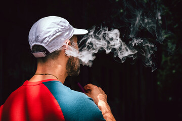 Man with beard smokes violet vape stick