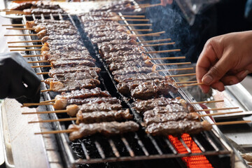Delicious grilled skewers of beef on fire. Thai street food market.