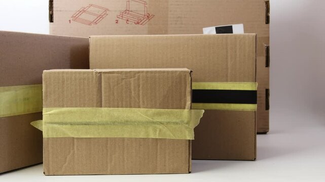 Man's hands picks up cardboard bpxes for delivery on a white background. Isolated. Delivery concept. 