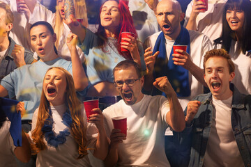 Excited crowd sitting on tribunes and watching sport game with scarfs to support their favorite team. People drinks beer and shouting. Concept of sport, competition, support, world, cup. Ad