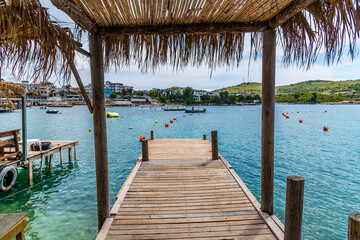 A view along a shady jetty on the main beach at Ksamil, Albania in summertime