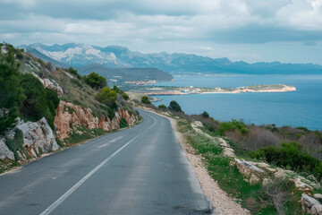 empty coastal road in the morning with the sea and mountains in the background