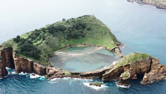 Aerial view of tranquil lagoon with azure water and lush vegetation, Vila Franca do Campo, Azores, Portugal.