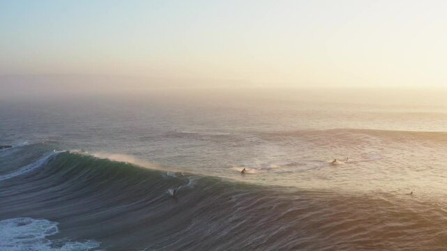 Aerial view of big waves and surfers in Nazare, Leiria, Portugal.