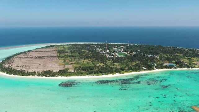 Aerial view of turquoise waters and coral reefs surrounding Thoddoo Island, Maldives.