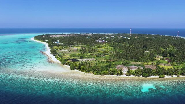 Aerial view of idyllic island with turquoise ocean and coral reef, Thoddoo, Maldives.