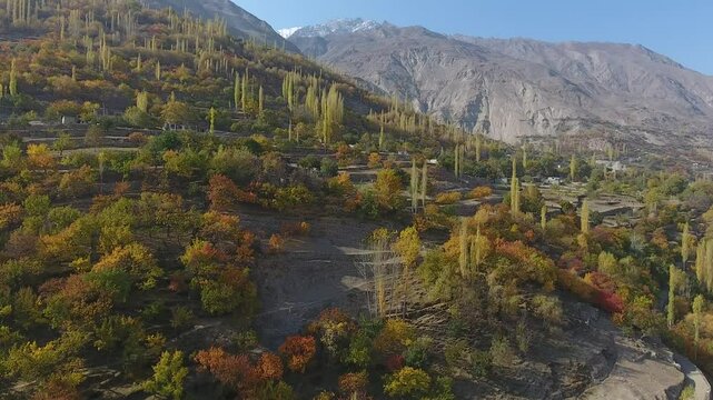 Aerial view of majestic Himalayan mountains and vibrant autumn foliage in Hunza Valley, Gilgit-Baltistan, Pakistan.